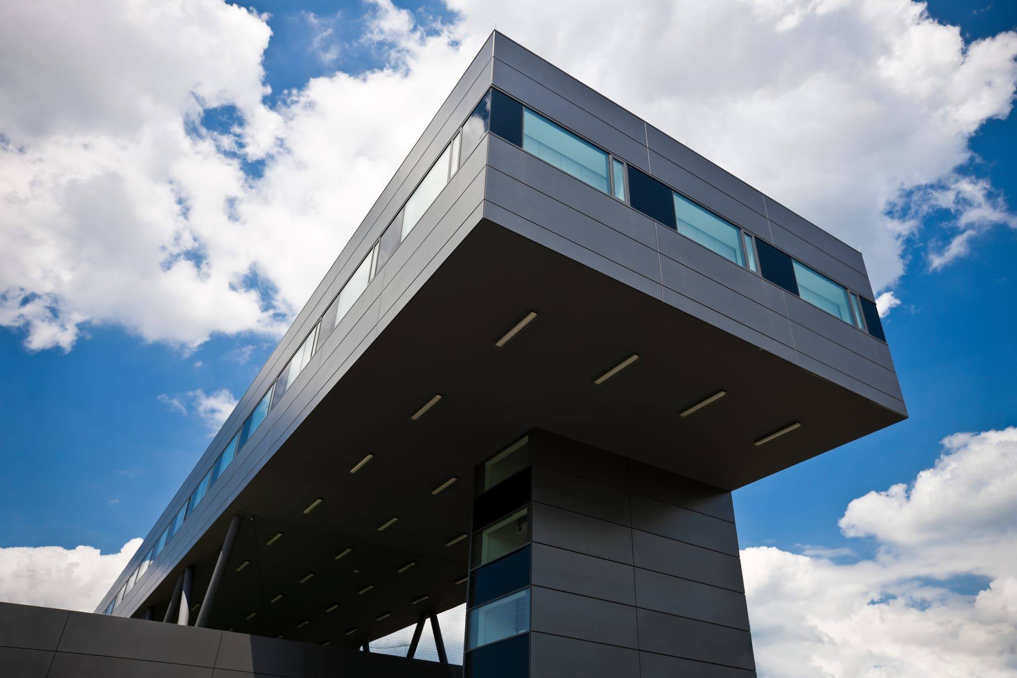 Modernes, auskragendes Bürogebäude vor blauem Himmel